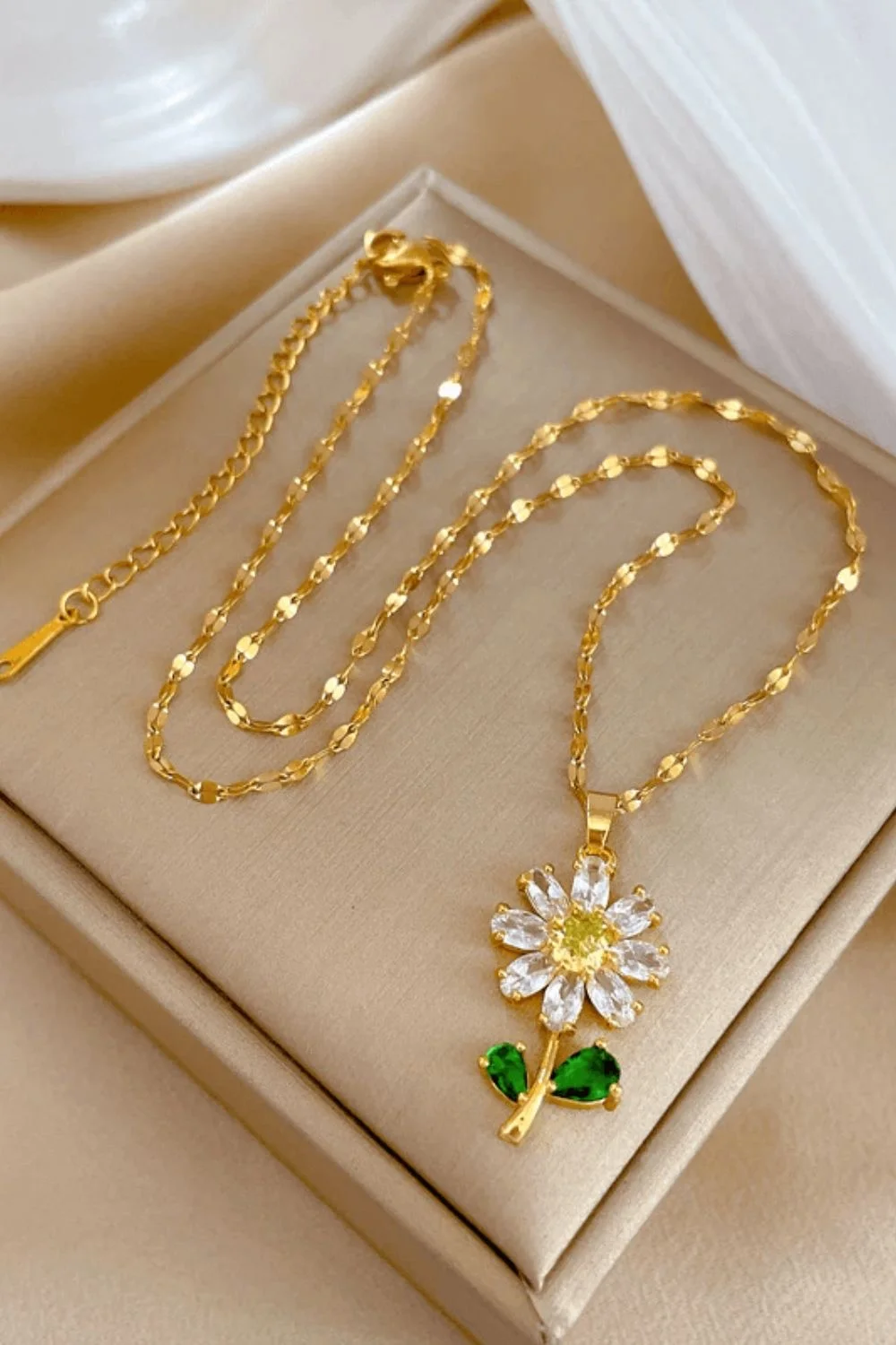 Cadena dorada con dije de flor blanca